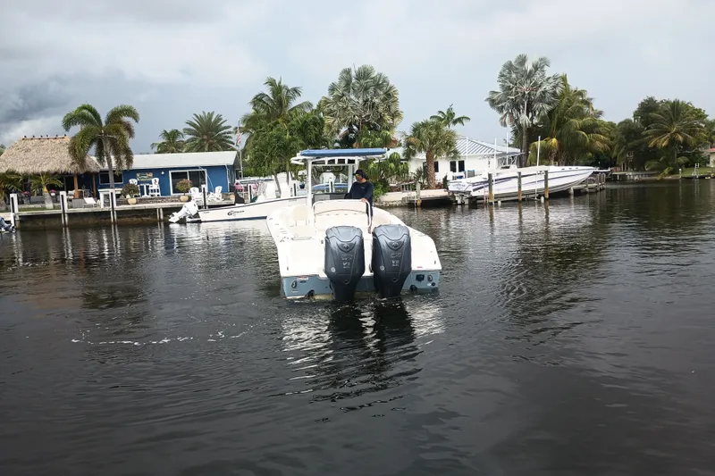 Slide: The Image of 2021 Sea Hunt Gamefish 27FS boat on a calm waterfront with palm trees. - 38