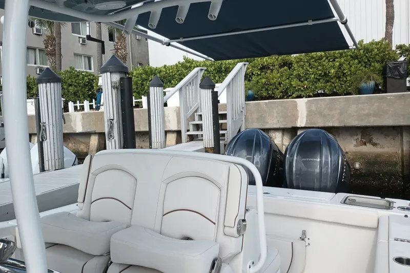 Slide: The Image of 2021 Sea Hunt Gamefish 27FS boat with dual engines docked at a marina. - 19