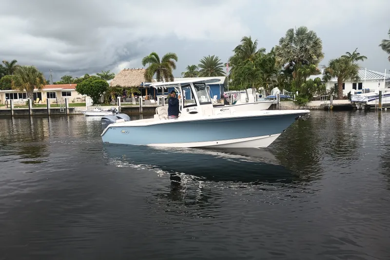 Slide: The Image of 2021 Sea Hunt Gamefish 27FS boat cruising on a calm waterway near palm trees. - 37