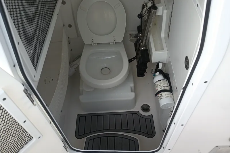 Slide: The Image of 2021 Sea Hunt Gamefish 27FS boat toilet with safety equipment and storage. - 32
