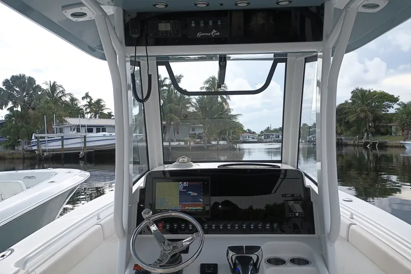 Slide: The Image of 2021 Sea Hunt Gamefish 27FS boat cockpit with steering wheel and navigation display. - 16