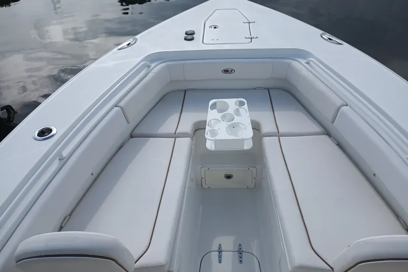 Slide: The Image of 2021 Sea Hunt Gamefish 27FS boat interior with cushioned seating and cup holders. - 12