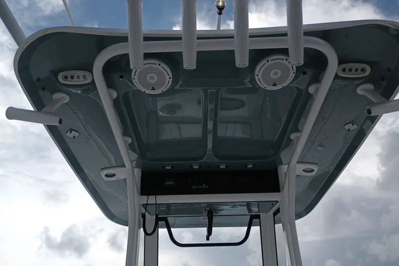 Slide: The Image of 2021 Sea Hunt Gamefish 27FS boat T-top with rod holders and speakers against cloudy sky. - 18