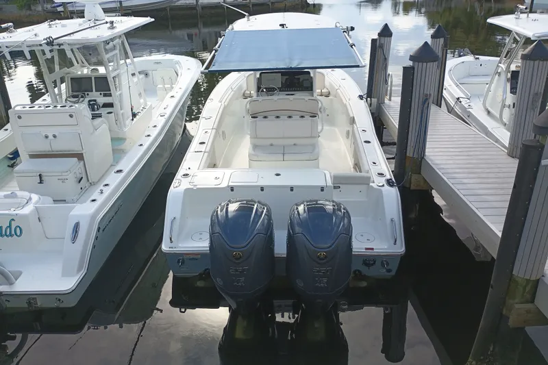 Slide: The Image of 2021 Sea Hunt Gamefish 27FS boat docked with twin engines and canopy. - 6