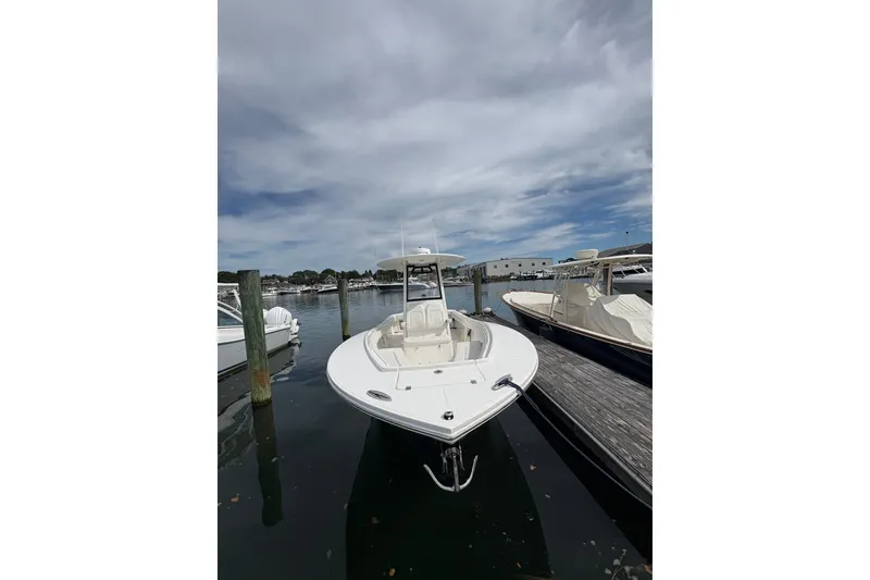 Slide: The Image of 2025 Regulator 25 boat docked at marina under cloudy sky. - 2
