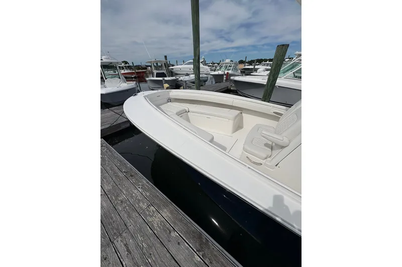 Slide: The Image of 2025 Regulator 25 boat docked at marina under cloudy sky. - 12