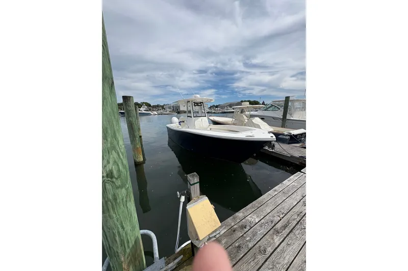 Slide: The Image of 2025 Regulator 25 boat docked at marina under cloudy sky. - 13