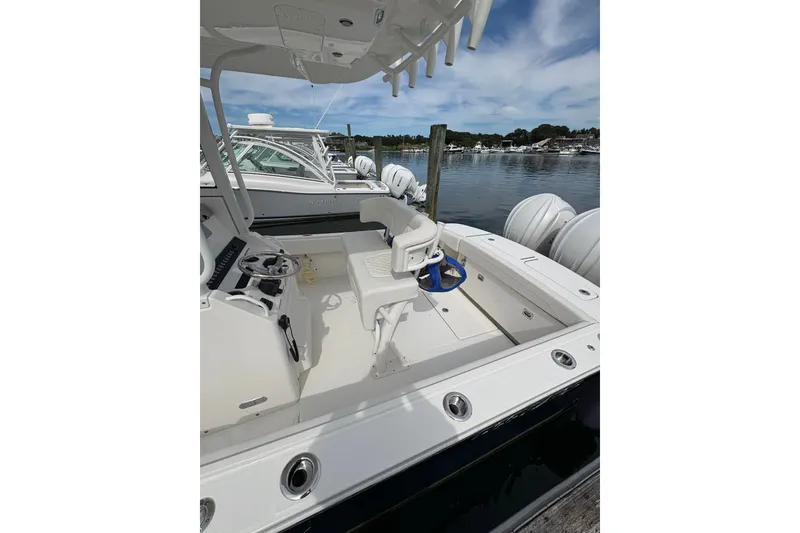 Slide: The Image of 2025 Regulator 25 boat interior with helm, seating, and water view. - 14