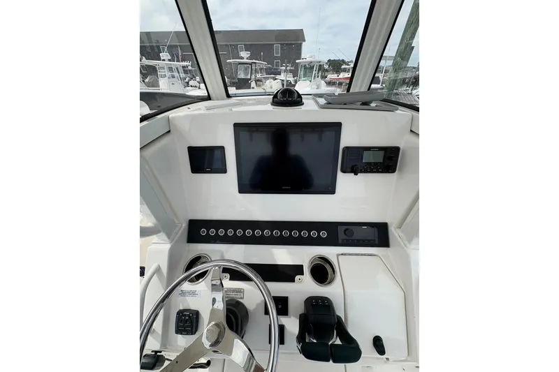 Slide: The Image of 2025 Regulator 25 boat dashboard with steering wheel and electronic controls. - 10