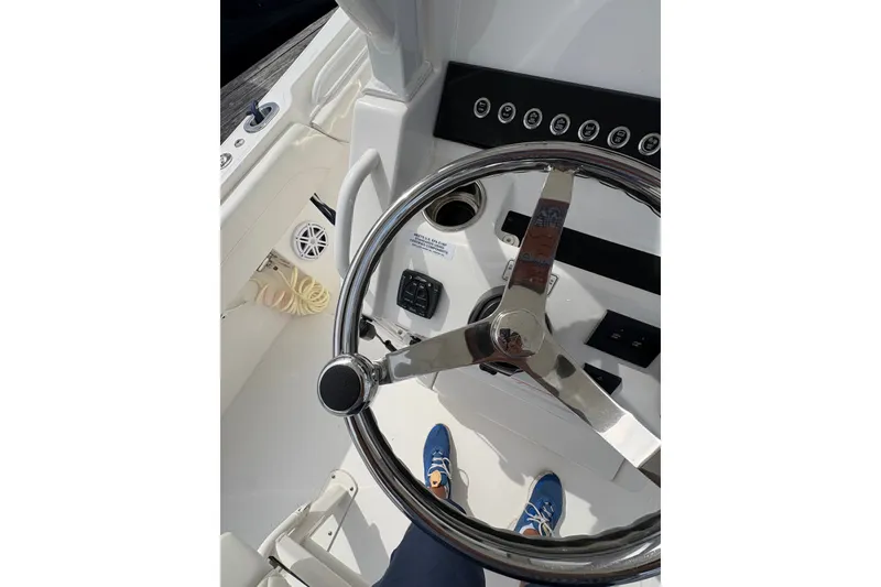 Slide: The Image of Steering wheel of a 2025 Regulator 25 boat, showcasing control panel and deck details. - 15
