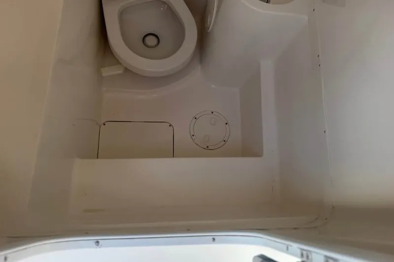 Slide: The Image of 2006 Fountain 32 Center Console boat bathroom interior with toilet and storage compartment. - 15