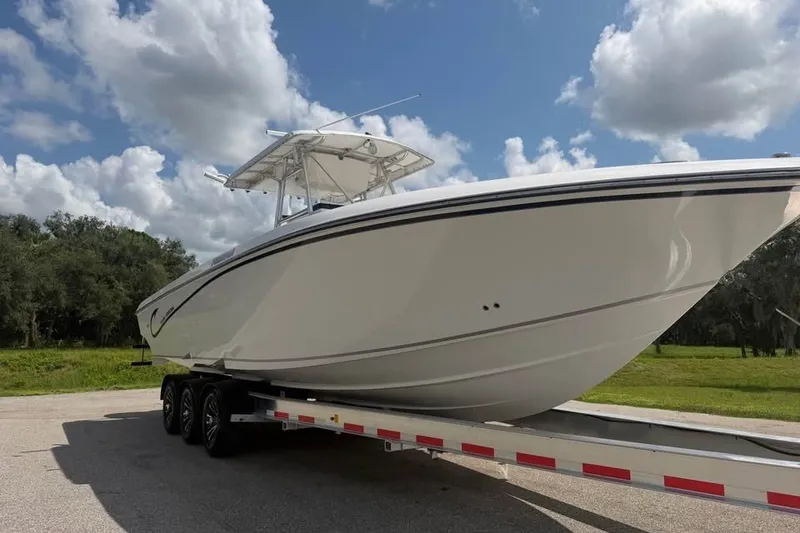 Slide: The Image of 2006 Fountain 32 Center Console boat on trailer under a partly cloudy sky. - 3