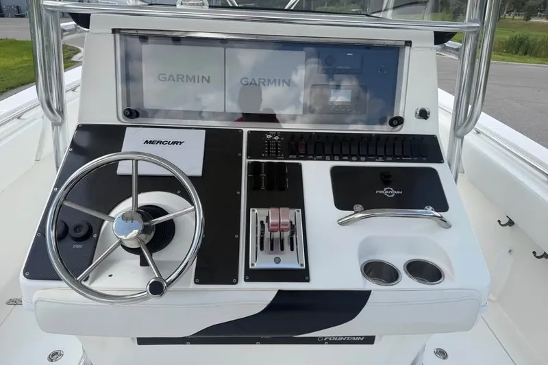 Slide: The Image of 2006 Fountain 32 Center Console boat dashboard with Garmin displays and Mercury controls. - 13