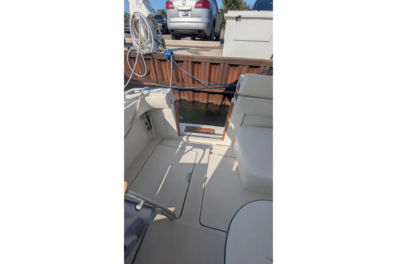 Slide: The Image of 1988 Tiara 33 Express boat interior with dock view, featuring seating and storage. - 10