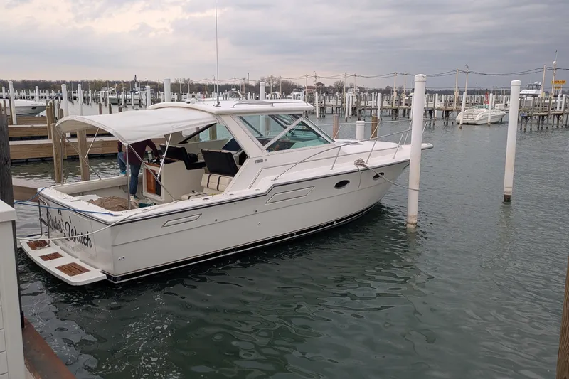 Slide: The Image of 1988 Tiara 33 Express yacht docked at marina under cloudy sky. - 1