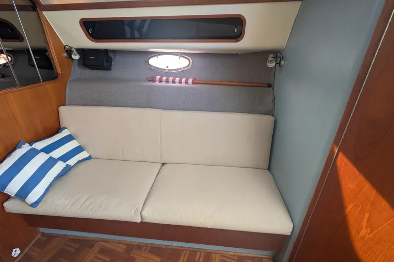 Slide: The Image of Interior of 1988 Tiara 33 Express yacht with beige sofa and striped pillows. - 15