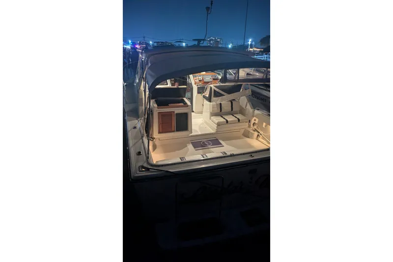 Slide: The Image of 1988 Tiara 33 Express boat illuminated at night, showcasing its spacious deck and seating area. - 20
