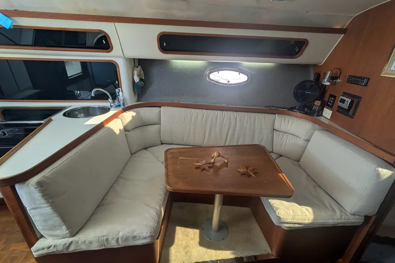 Slide: The Image of 1988 Tiara 33 Express cabin interior with cushioned seating and wooden table. - 14