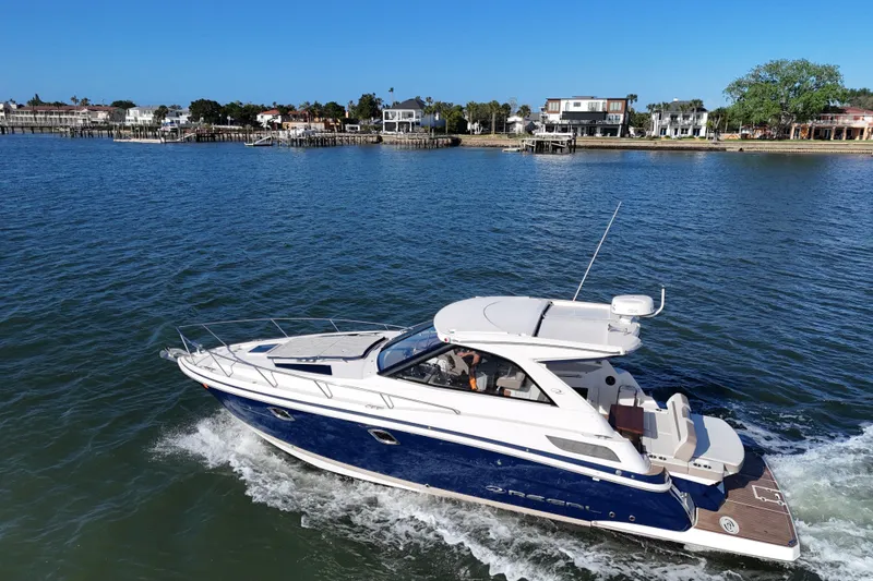 Slide: The Image of 2016 Regal 35 Sport Coupe cruising on a sunny day near waterfront homes. - 7