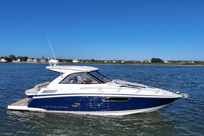Slide: The Image of 2016 Regal 35 Sport Coupe cruising on a sunny day, with coastal homes in the background. - 85