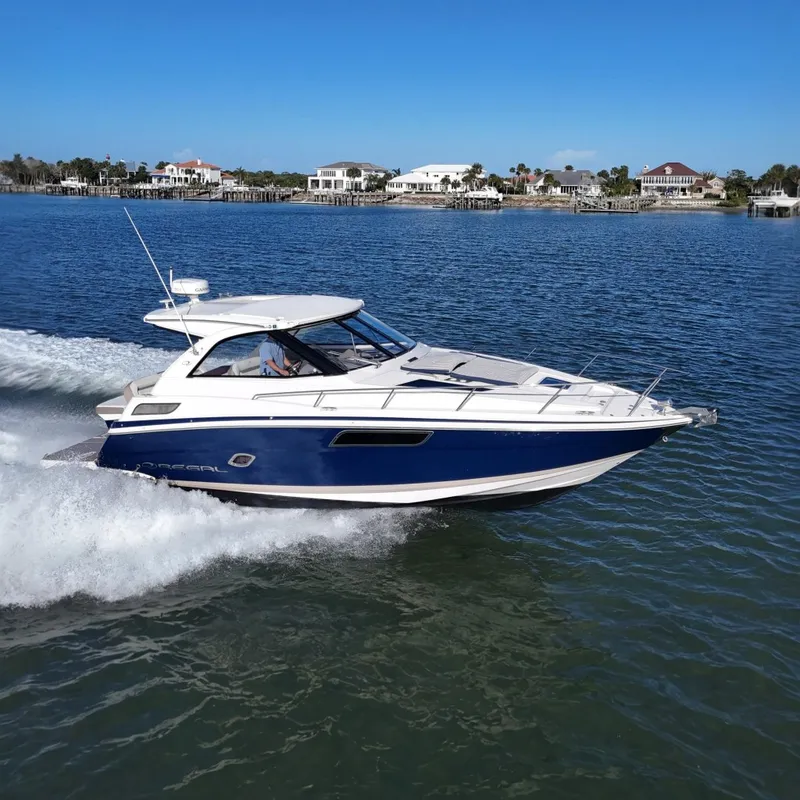 The Image of 2016 Regal 35 Sport Coupe cruising on a sunny day near waterfront homes. - 0