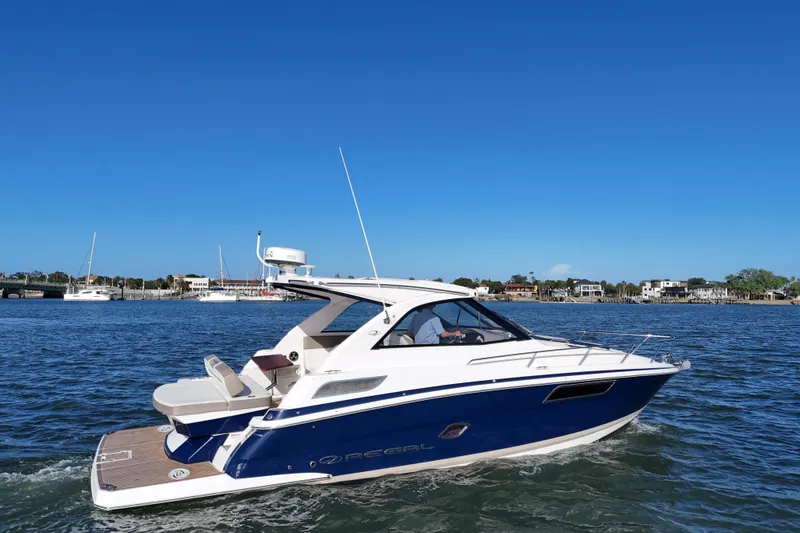 Slide: The Image of 2016 Regal 35 Sport Coupe cruising on a sunny day, with coastal homes in the background. - 16