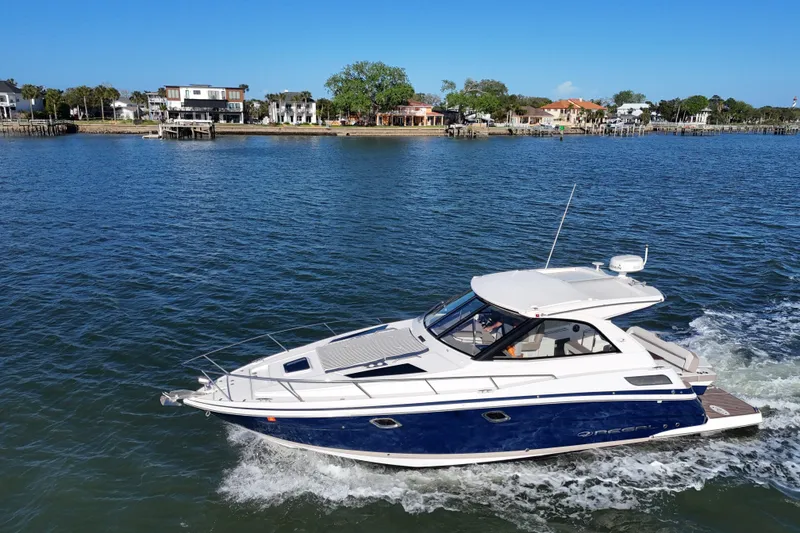 Slide: The Image of 2016 Regal 35 Sport Coupe cruising on a scenic waterfront with houses in the background. - 6