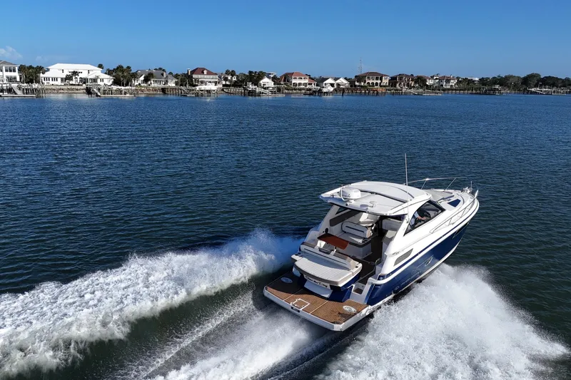 Slide: The Image of 2016 Regal 35 Sport Coupe cruising on a scenic waterfront with houses in the background. - 10