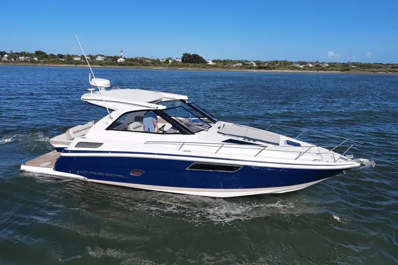 Slide: The Image of 2016 Regal 35 Sport Coupe cruising on open water under clear blue skies. - 82