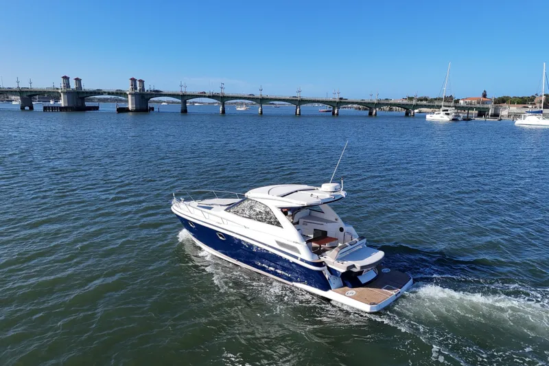 Slide: The Image of 2016 Regal 35 Sport Coupe cruising on a scenic river near a bridge. - 12