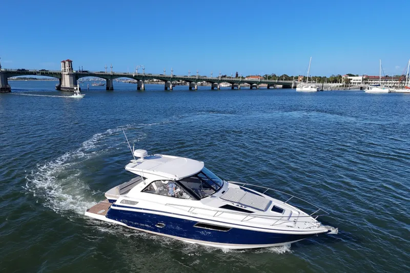Slide: The Image of 2016 Regal 35 Sport Coupe cruising near a scenic bridge on a sunny day. - 62
