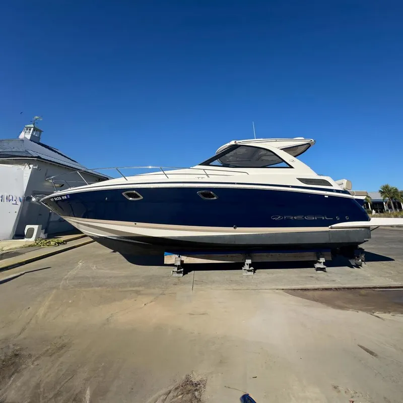 Slide: The Image of 2016 Regal 35 Sport Coupe boat on display under clear blue sky. - 96