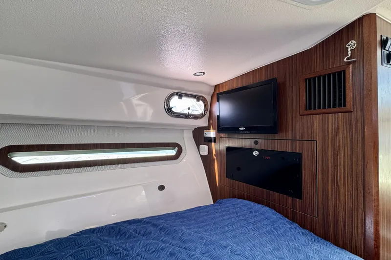Slide: The Image of Interior cabin of 2017 Pursuit OS 325 Offshore with TV and wood paneling. - 22