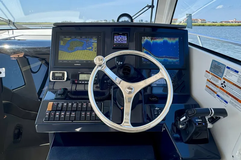 Slide: The Image of Helm of 2017 Pursuit OS 325 Offshore boat with navigation displays and controls. - 6