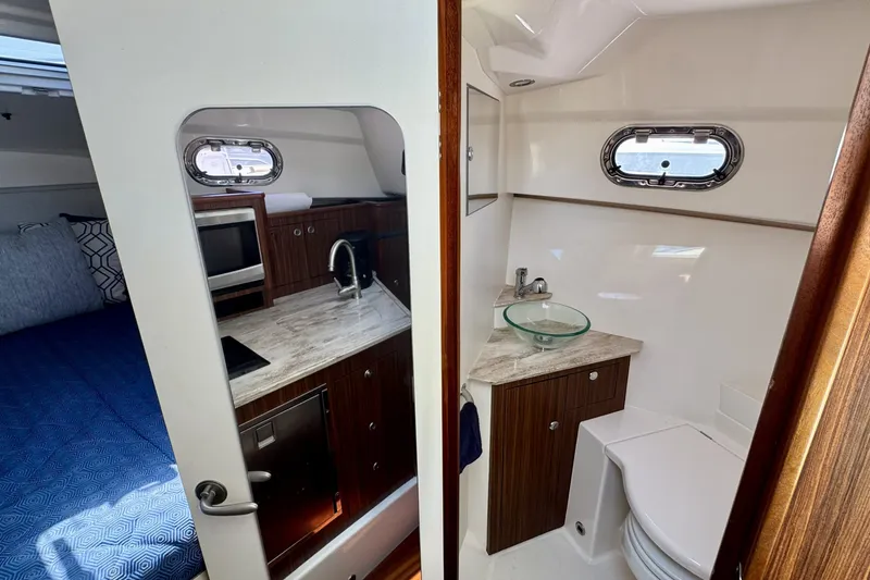 Slide: The Image of 2017 Pursuit OS 325 Offshore interior with kitchenette and bathroom. - 24