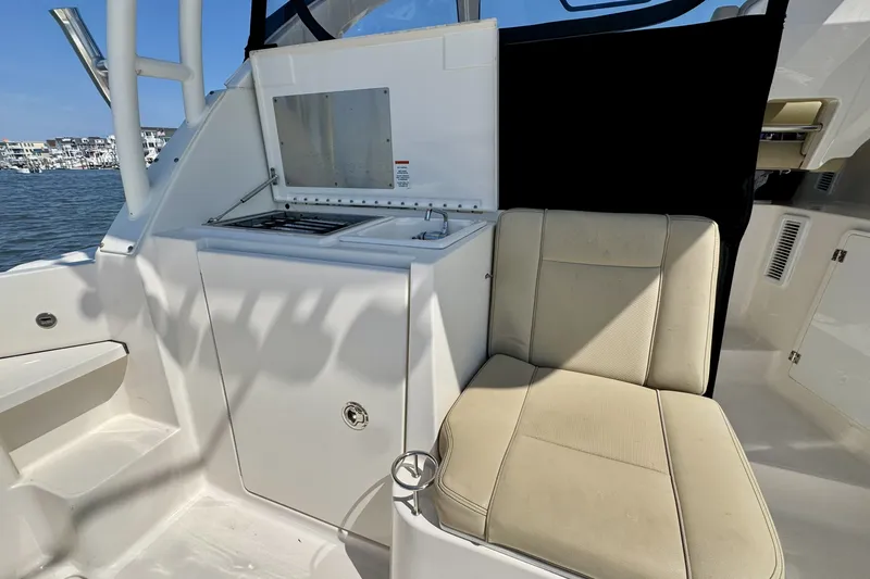 Slide: The Image of 2017 Pursuit OS 325 Offshore boat interior with seating and kitchenette area. - 14