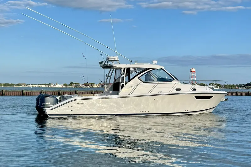 Slide: The Image of 2017 Pursuit OS 325 Offshore boat on calm water, clear sky background. - 2