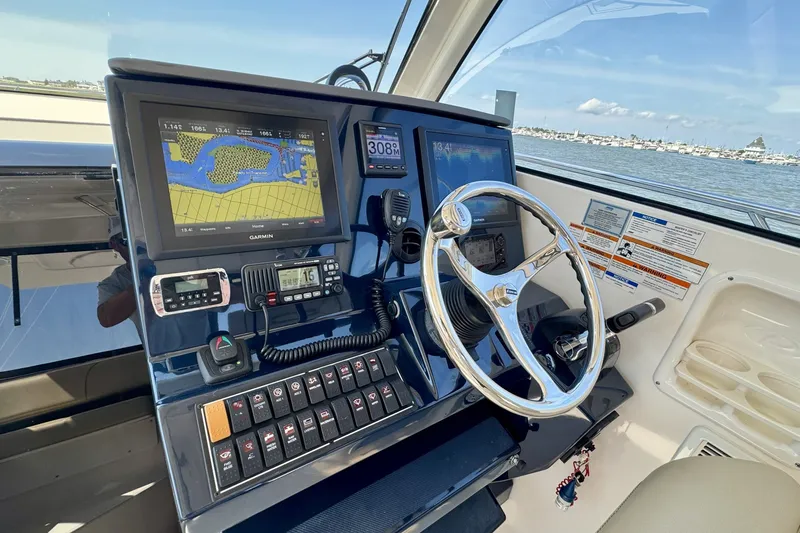 Slide: The Image of 2017 Pursuit OS 325 Offshore helm with Garmin navigation system and steering wheel. - 7
