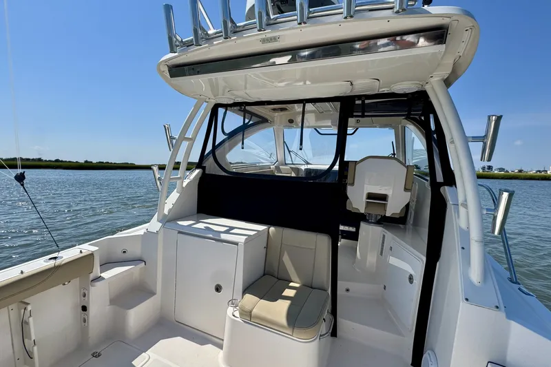 Slide: The Image of 2017 Pursuit OS 325 Offshore boat interior with seating, on calm water. - 10