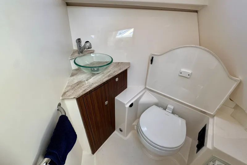 Slide: The Image of 2017 Pursuit OS 325 Offshore boat bathroom with modern sink and toilet. - 25