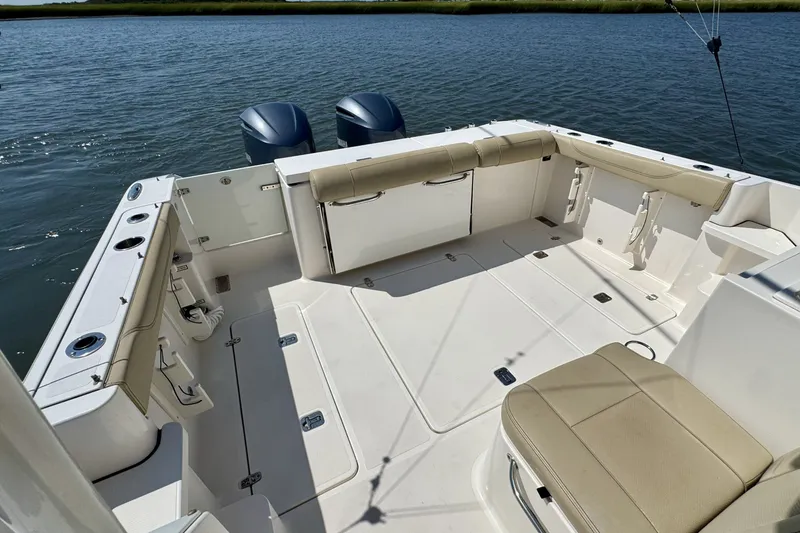 Slide: The Image of 2017 Pursuit OS 325 Offshore boat interior with seating and dual engines on water. - 11