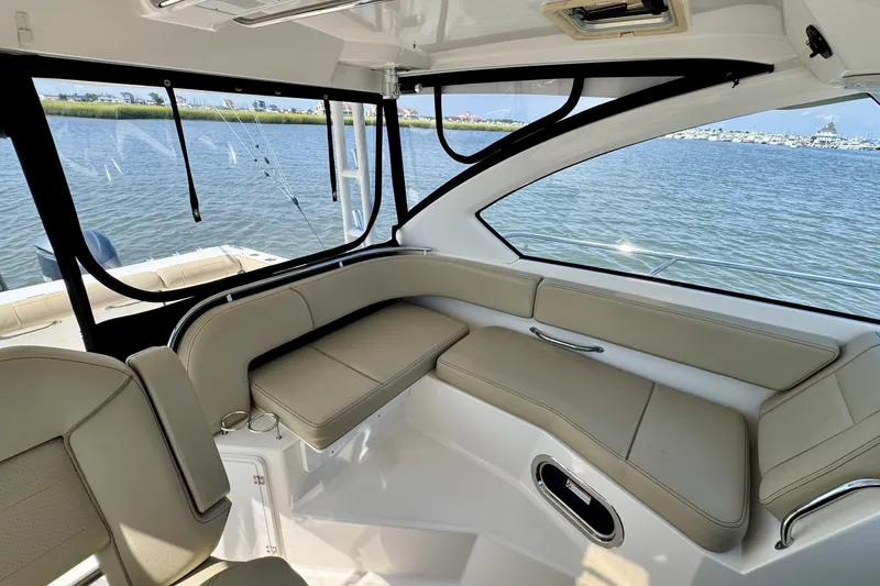 Slide: The Image of Interior of 2017 Pursuit OS 325 Offshore boat with beige seating and water view. - 8