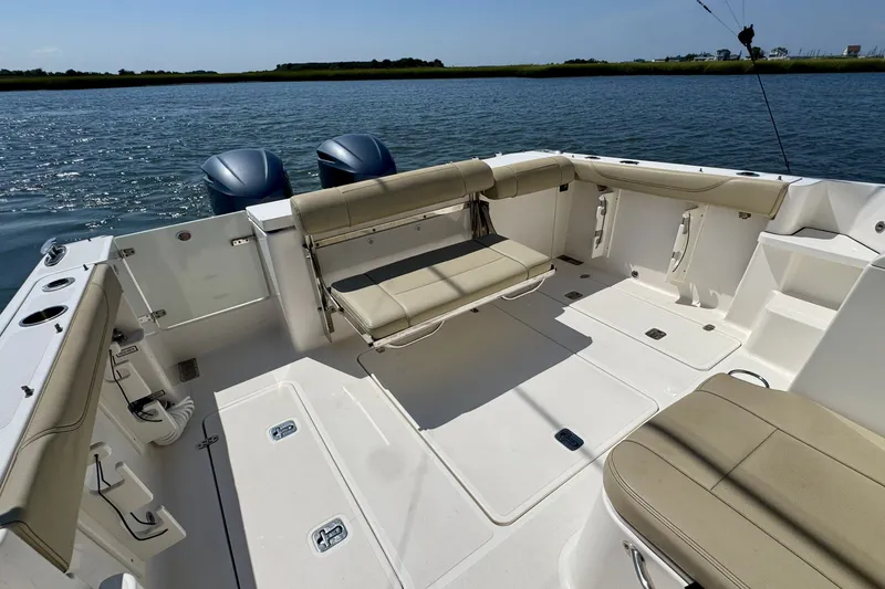 Slide: The Image of 2017 Pursuit OS 325 Offshore boat interior with seating, on a calm water backdrop. - 12