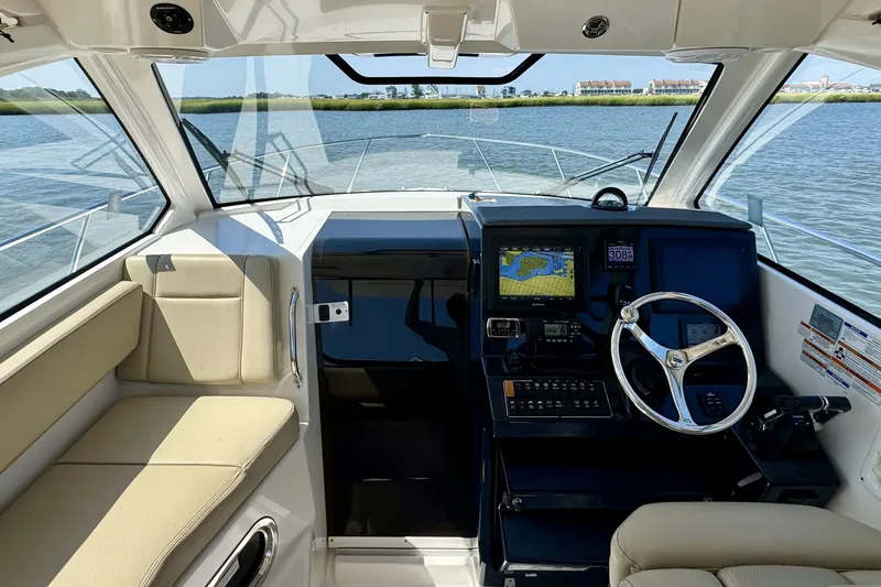 Slide: The Image of 2017 Pursuit OS 325 Offshore boat interior with navigation system and steering wheel. - 5