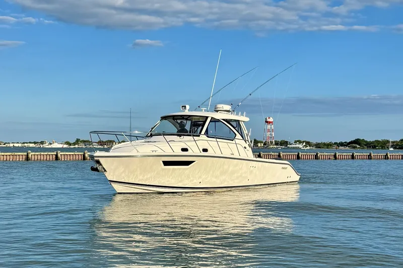 Slide: The Image of 2017 Pursuit OS 325 Offshore boat on calm water under blue sky. - 1