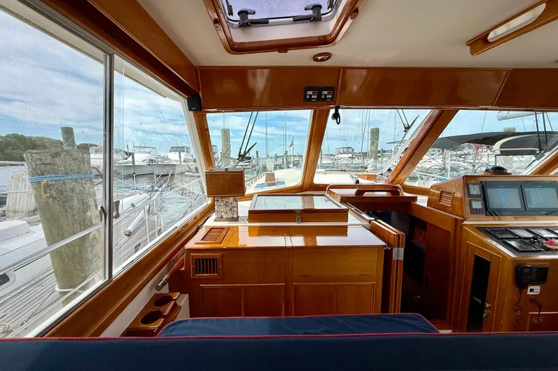Slide: The Image of Interior view of 2001 Grand Banks 49 Eastbay HX yacht with wooden finishes and marina backdrop. - 64