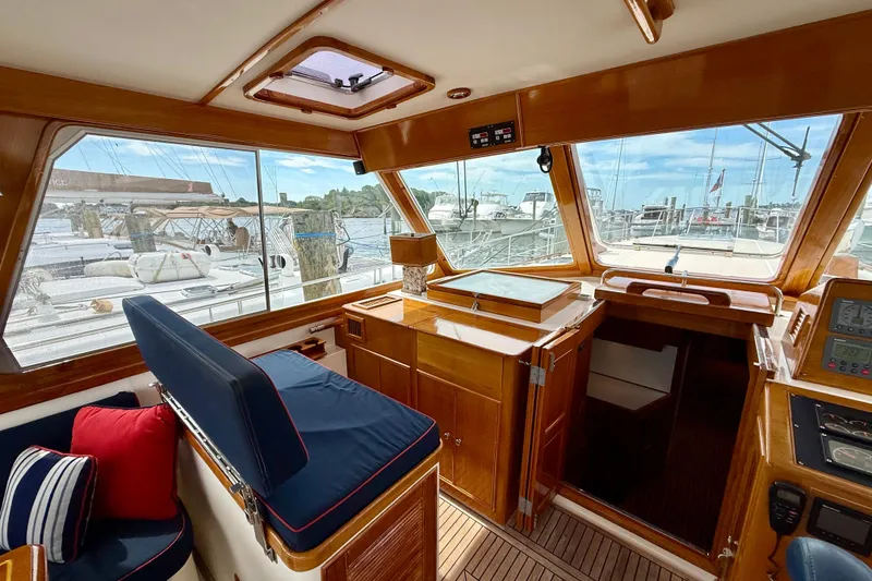 Slide: The Image of Interior view of 2001 Grand Banks 49 Eastbay HX yacht with wooden finish and marina backdrop. - 63