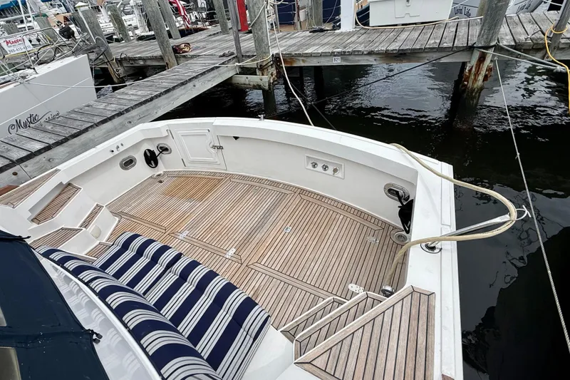Slide: The Image of 2001 Grand Banks 49 Eastbay HX yacht with teak deck and striped seating at a marina. - 15
