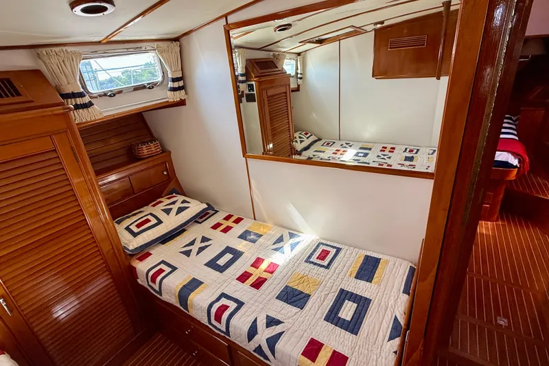 Slide: The Image of Cozy cabin interior of 2001 Grand Banks 49 Eastbay HX with nautical-themed bedding. - 44