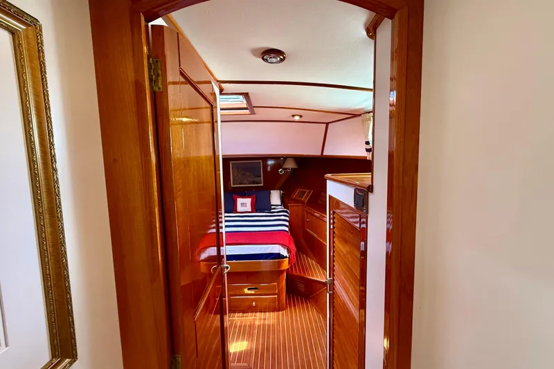 Slide: The Image of Luxurious 2001 Grand Banks 49 Eastbay HX cabin with elegant wood finish and cozy bedding. - 33